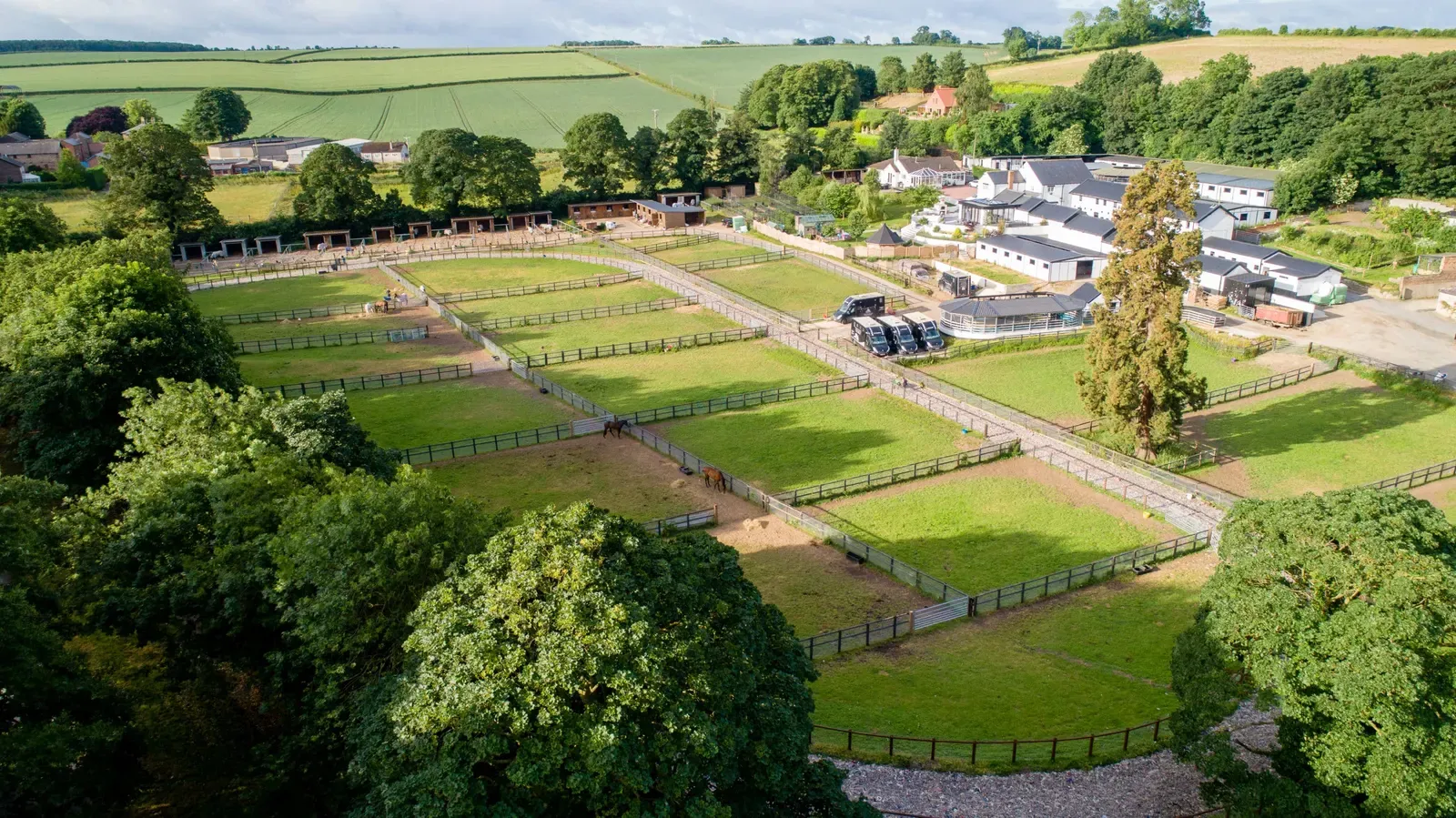 Aerial view of Spring Cottage Stables, its turn out paddocks, training yard and buildings